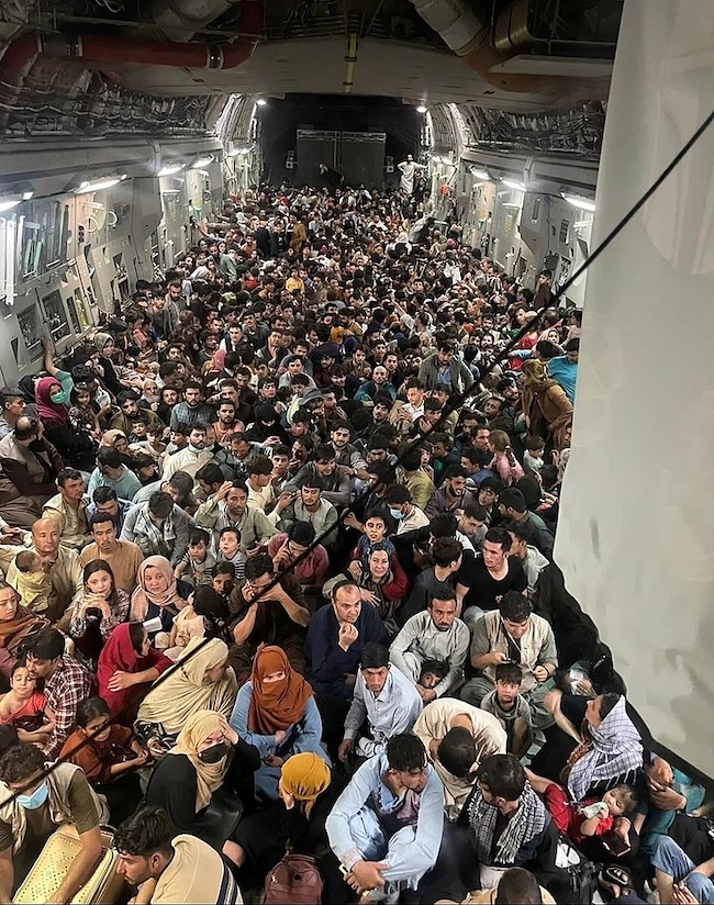 De evacuatie van vluchtelingen uit Afghanistan. Air Mobility Command Public Affairs, C-17 carrying passengers out of Afghanistan (2021). Bron: Wikimedia Commons (Public Domain)
