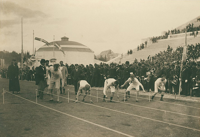 De atleten van de eerste moderne Spelen bereiden zich voor op de 100 meter sprint. Albert Meyer, Preparation for the 100-meter race (1896). Bron: Wikimedia Commons (CC0)