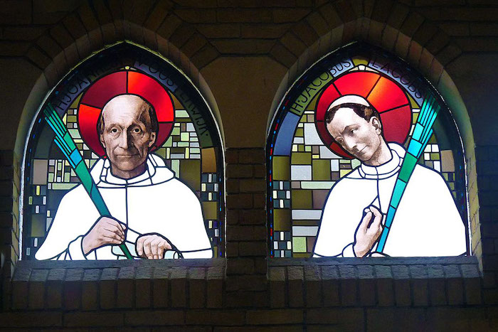 Een glas-in-loodafbeelding van twee martelaren van Gorcum in de Amsterdamse Martelaren van Gorcumkerk. Luc, Martelaren van Gorcumkerk (2016). Bron: Wikimedia Commons (CC BY-SA 4.0)