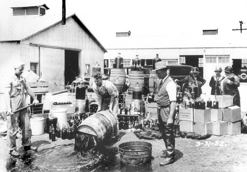 Hulpsheriffs dumpen een grote vangst illegale alcohol. Onbekende fotograaf, Orange County Sherrif's deputies dumping illegal booze (1932). Bron: Flickr Orange County Archives (CC BY 2.0)