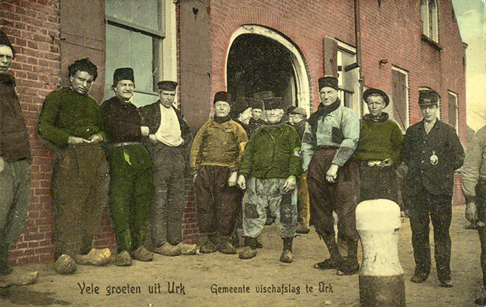 Onbekende maker, Groep vissers bij de visafslag op Urk (ca. 1910). Bron: Noord-Hollands Archief (PD)